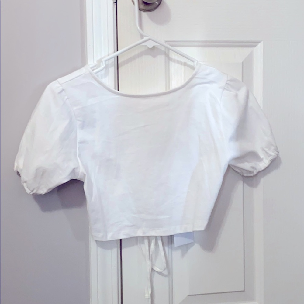 White puffed shoulder top. Open back with ties.